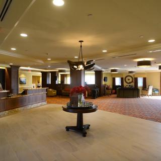 A spacious hotel lobby with a reception desk and elegant decor.