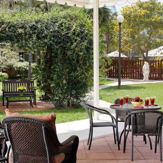 A serene patio area with outdoor seating surrounded by lush greenery.
