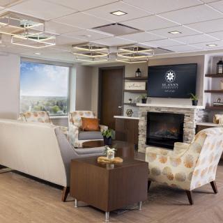 A modern lounge area featuring comfortable seating, a fireplace, and a television.
