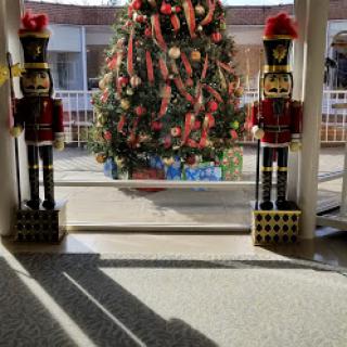 A festive display featuring a beautifully decorated Christmas tree flanked by nutcracker figures.