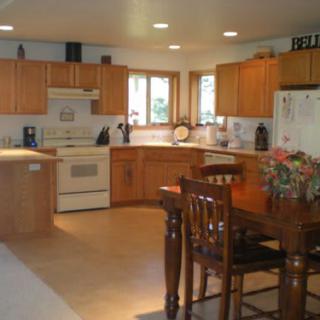 A spacious kitchen with wooden cabinets and a dining area.