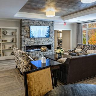 A cozy living room featuring a stone fireplace and modern decor.