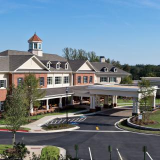 A modern healthcare facility with a landscaped exterior and clear skies.