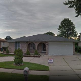 A suburban home with a well-maintained front yard and a garage, set against a cloudy sky.
