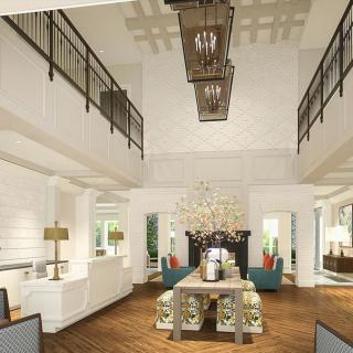 A modern living room with a high ceiling and elegant chandelier, featuring a dining area and comfortable seating.