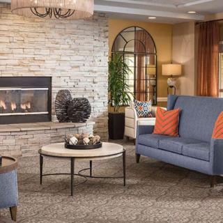 A cozy living room with a modern fireplace, stylish sofa, and decorative elements.