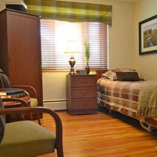 A cozy bedroom with wooden furniture and warm lighting.