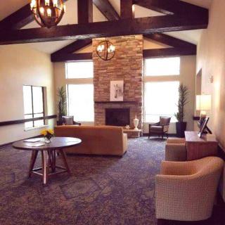 A cozy living room with a stone fireplace, comfortable seating, and elegant decor.