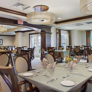An elegant dining room with neatly arranged tables and chairs, ready to host guests.