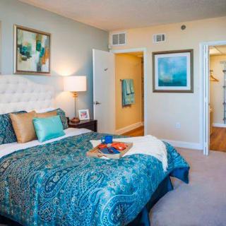 A modern bedroom featuring elegant decor, vibrant bedding, and stylish artwork.