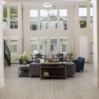 A spacious living room featuring modern furniture and large windows allowing ample natural light.