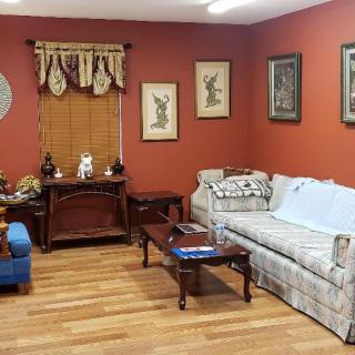 A cozy living room with a sofa, coffee table, and decorative artwork on the walls.