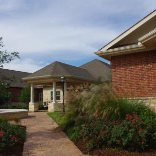A red brick house with a landscaped garden and a pathway leading to the front entrance.