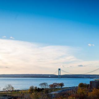 A scenic view of a bridge spanning across a body of water under a clear blue sky.