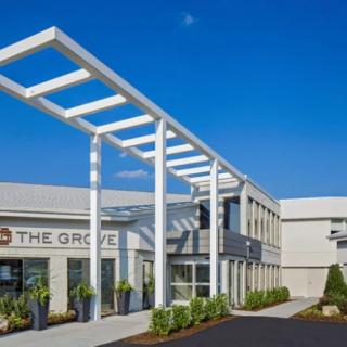 The entrance of a modern commercial building under a clear blue sky.