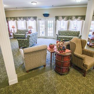 A cozy living room with multiple seating areas and large windows.