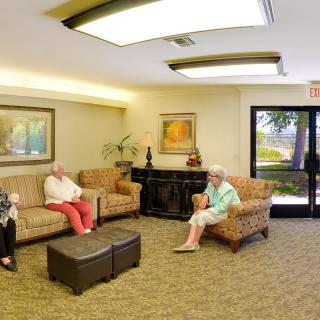 A cozy waiting room with people seated on sofas and chairs.