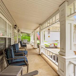 A spacious porch with outdoor seating and decorative columns.