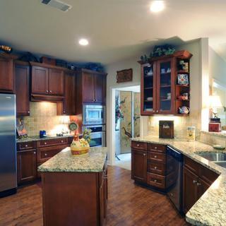 A modern kitchen with wood cabinets and granite countertops.