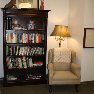 A cozy reading nook with a well-stocked bookshelf and a comfortable armchair.