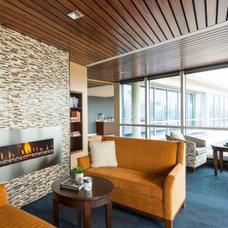 A modern, cozy living room with a fireplace and large windows.