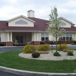 A residential building with well-maintained landscaping and a circular driveway.
