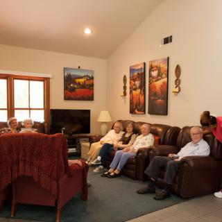 A group of people relaxing in a living room with comfortable seating and wall art.