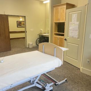 A view of a hospital room featuring an adjustable bed and medical furniture.