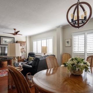 A cozy living room and dining area featuring a wooden table, comfortable seating, and stylish lighting.
