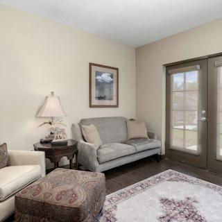 A cozy living room featuring a comfortable sofa, armchair, and natural light from the windows.