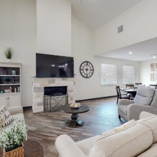 A modern living room with a fireplace, large television, and comfortable seating.