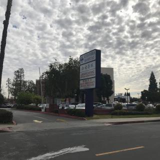 A view of an urban area with a cloudy sky and street signage.