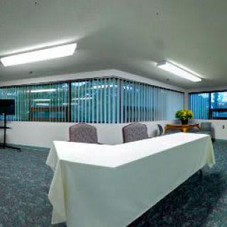 A well-lit conference room with a long meeting table and chairs.