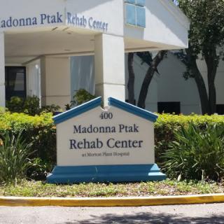 Madonna Peak Rehab Center sign in a landscaped area.