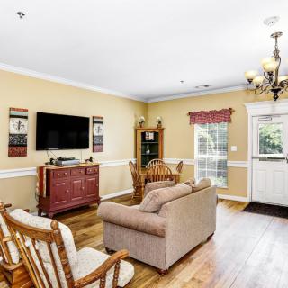 Cozy living room featuring a sofa, rocking chairs, and a television.