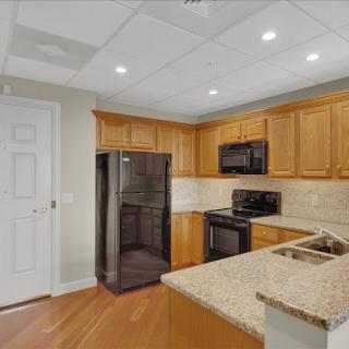 A modern kitchen featuring sleek wood cabinets and stainless steel appliances.
