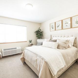 A bright, modern bedroom with neutral tones and minimalist decor.