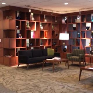 A modern lobby seating area featuring stylish furniture and unique shelving.