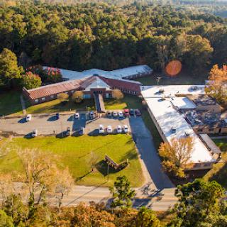 Aerial view of a commercial building surrounded by lush greenery.