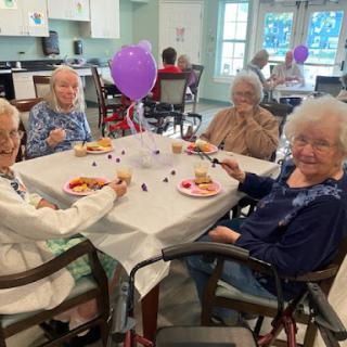 Residents enjoying a meal together at a community gathering, filled with laughter and celebration.