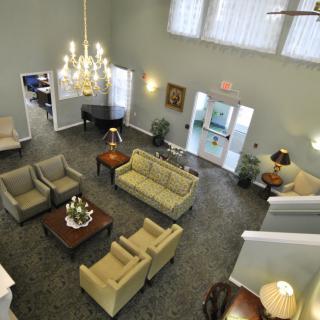 A well-decorated living room with sofas, chairs, a chandelier, and a coffee table.