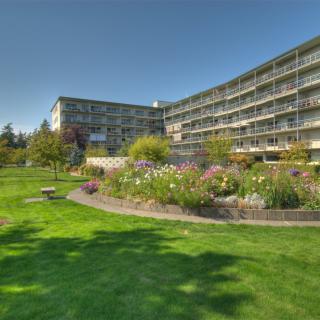 A beautiful residential building with well-maintained gardens and a lush green lawn.
