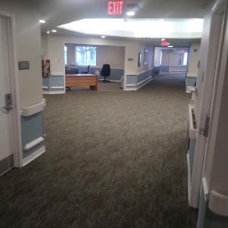 A view of a spacious and well-lit hallway in a healthcare facility.