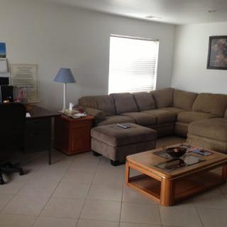 A cozy living room with a sectional sofa, coffee table, and lamp.