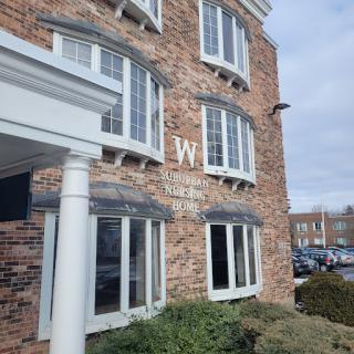 The exterior of a modern hotel featuring brick architecture and large windows.