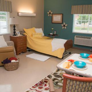 A cozy hospital room featuring yellow bedding and comfortable furnishings.