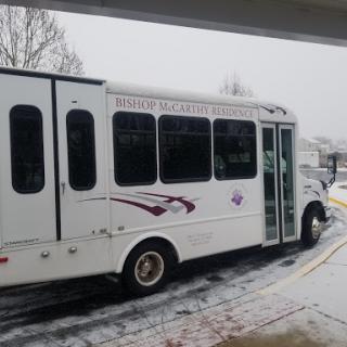 A white bus parked in a snowy environment, showcasing winter weather conditions.
