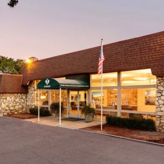Exterior view of a building entrance with an American flag and canopy during evening hours.