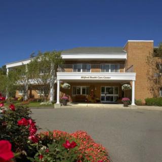 A building entrance surrounded by landscaped gardens and vibrant flowers.