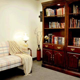 A cozy living room with a plaid sofa and a well-stocked bookshelf.